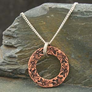 Small circle copper pendant stamped with flowers